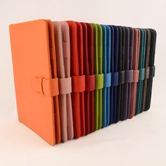 a row of different colored folders sitting next to each other on a white surface