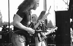 two men are playing guitars on stage