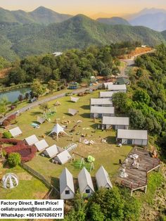 an aerial view of many tents in the middle of a field with mountains in the background