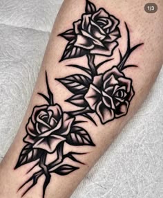 a black and white rose tattoo design on the left leg, with three roses in it