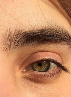 a close up of a person's eye with brown hair