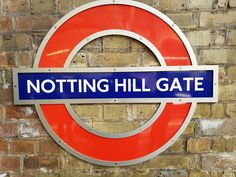 a sign on the side of a brick wall that says, notting hill gate