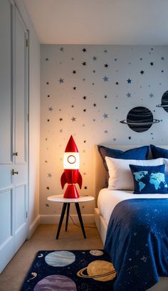 a bed room with a neatly made bed and a space themed wallpaper on the walls