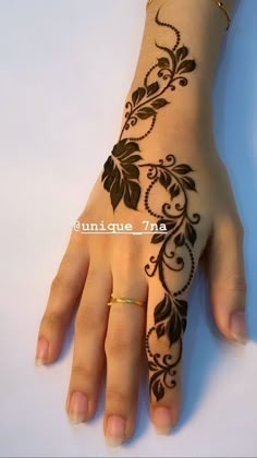 a woman's hand with henna tattoos on it