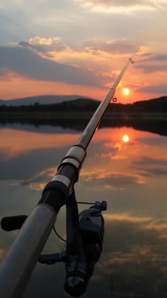 the sun is setting behind a fishing rod
