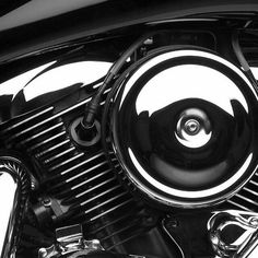 the front end of a black motorcycle with chrome spokes and an air cleaner hose