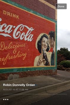 a large coca cola advertisement painted on the side of a building