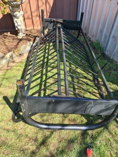 a metal bed frame sitting in the grass