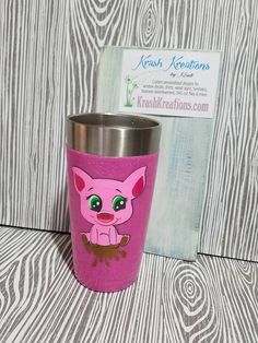 a pink cup sitting next to a business card