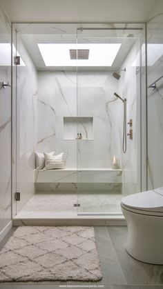 a white bathroom with a skylight above the bathtub and shower area, along with a rug on the floor