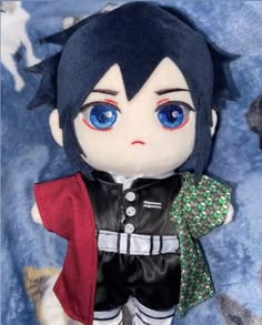 a close up of a stuffed animal with blue eyes and black hair wearing a costume