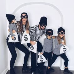 a group of people dressed in costumes holding bags with dollar signs on them and wearing masks