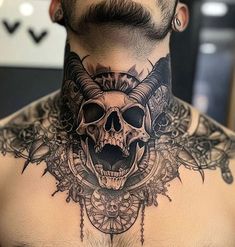 a man's neck with a skull and horns tattoo on the top of it