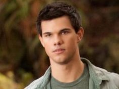 the young man is wearing a green shirt and looking at the camera with an intense look on his face