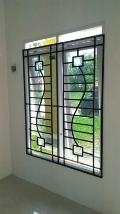 an empty room with two windows that have decorative glass designs on the outside and inside