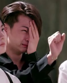 the man is holding his hand to his face