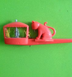 there is a toy cat on top of a shelf with people in the window inside