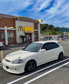 a white car parked in front of a mcdonald's