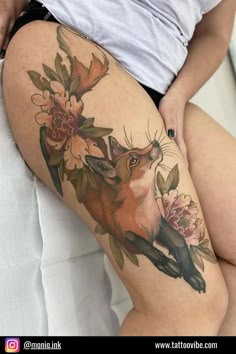 a woman's thigh with flowers and a fox on it