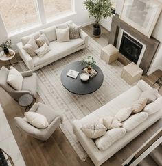 a living room filled with furniture and a fire place in the middle of a floor to ceiling window