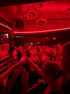 a group of people in a room with red lights