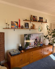 a flat screen tv sitting on top of a wooden entertainment center in a living room