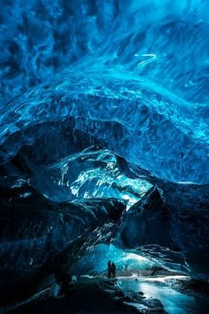 two people are standing in an ice cave