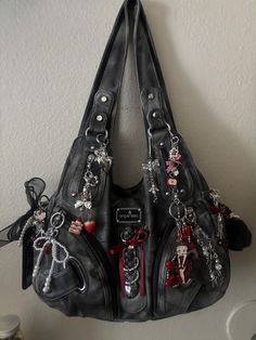 angel kiss bag deco keychains Angelkiss Purse, Skull Bag Charm, Angelkiss Bag Outfits, Angel Kiss Bag Black, Angelkiss Bags, Bag Decorations Ideas, Grunge Purses, 2000 Purse, Bags Accessories