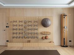 an exercise room with various equipment on the wall and wooden flooring, along with a yoga mat