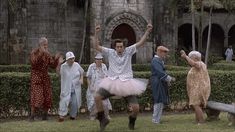 a group of people standing around each other in front of a building with faces drawn on them