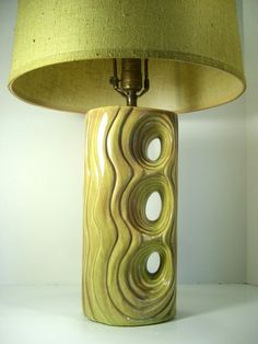 a lamp that is on top of a table with a green shade over the base
