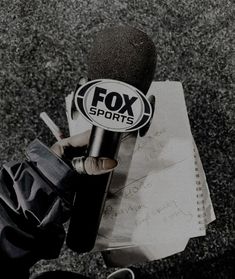 a person holding a microphone in front of a piece of paper with the words fox sports on it