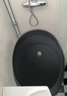 a black and white tiled bathroom with a round sink