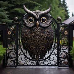 an owl statue sitting on top of a gate