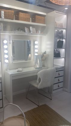 a white vanity with lights on it and a chair in front of the mirror that is lit up