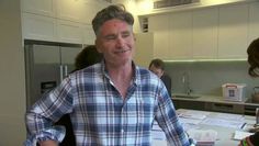 a man standing in front of a counter with papers on it and people around him