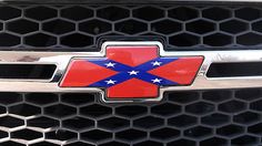 the front grille of a car with a red, white and blue flag on it