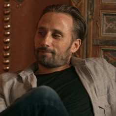 a man sitting in a chair with his eyes closed and looking off to the side