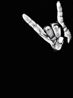 two hands making the v sign with their fingers in black and white photo against a dark background
