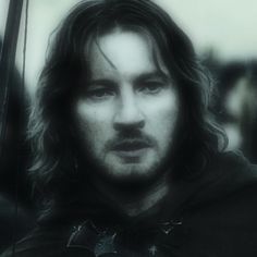 a man with long hair wearing a hoodie and holding an umbrella in front of him