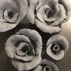 four white roses sitting on top of a table