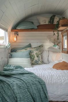 there is a bed with pillows and blankets in the room that looks like a tiny house