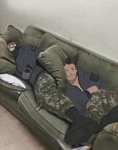 a man laying on top of a green couch