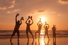 four people are standing on the beach holding up letters that spell out'fam '