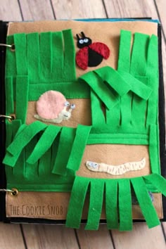 an open book with paper cut out of it's pages and some felt animals