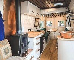 the interior of a tiny home with wood flooring and white cabinets, including an oven