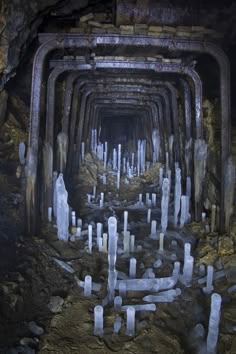 the inside of a tunnel that is filled with lots of white rocks and pillars in it