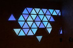 a room with several triangular shaped windows lit up by blue light from the window sill