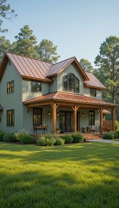 a large house with a metal roof in the middle of a grassy area next to trees