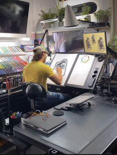 a man sitting at a desk in front of a computer monitor with pictures on it